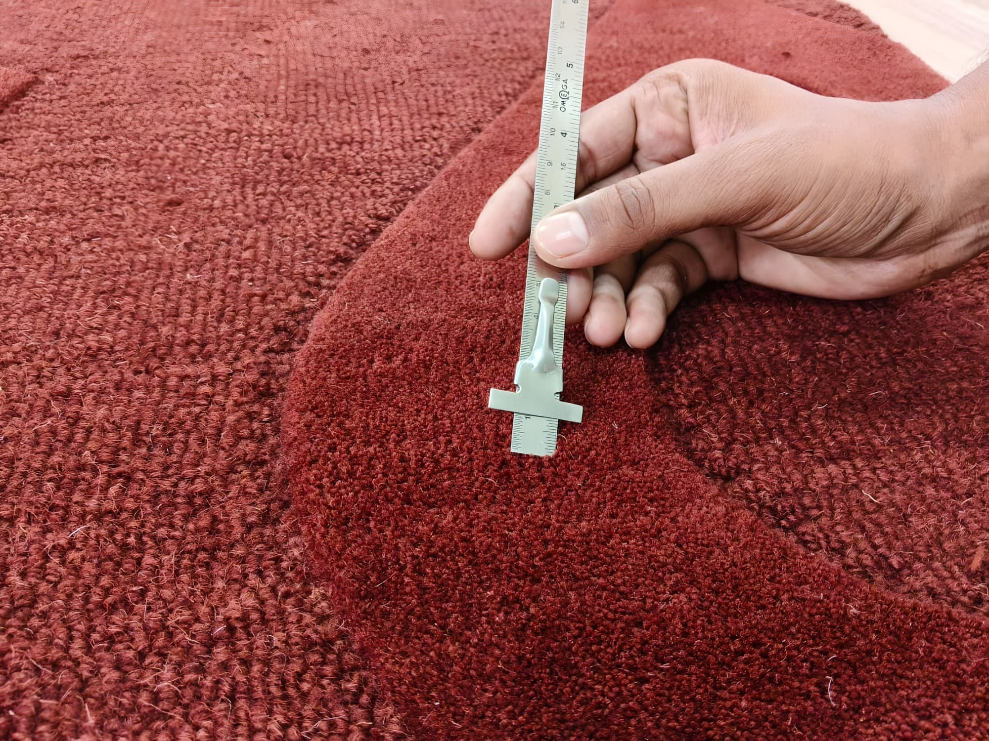 Measuring the pile of a hand-carved red rug