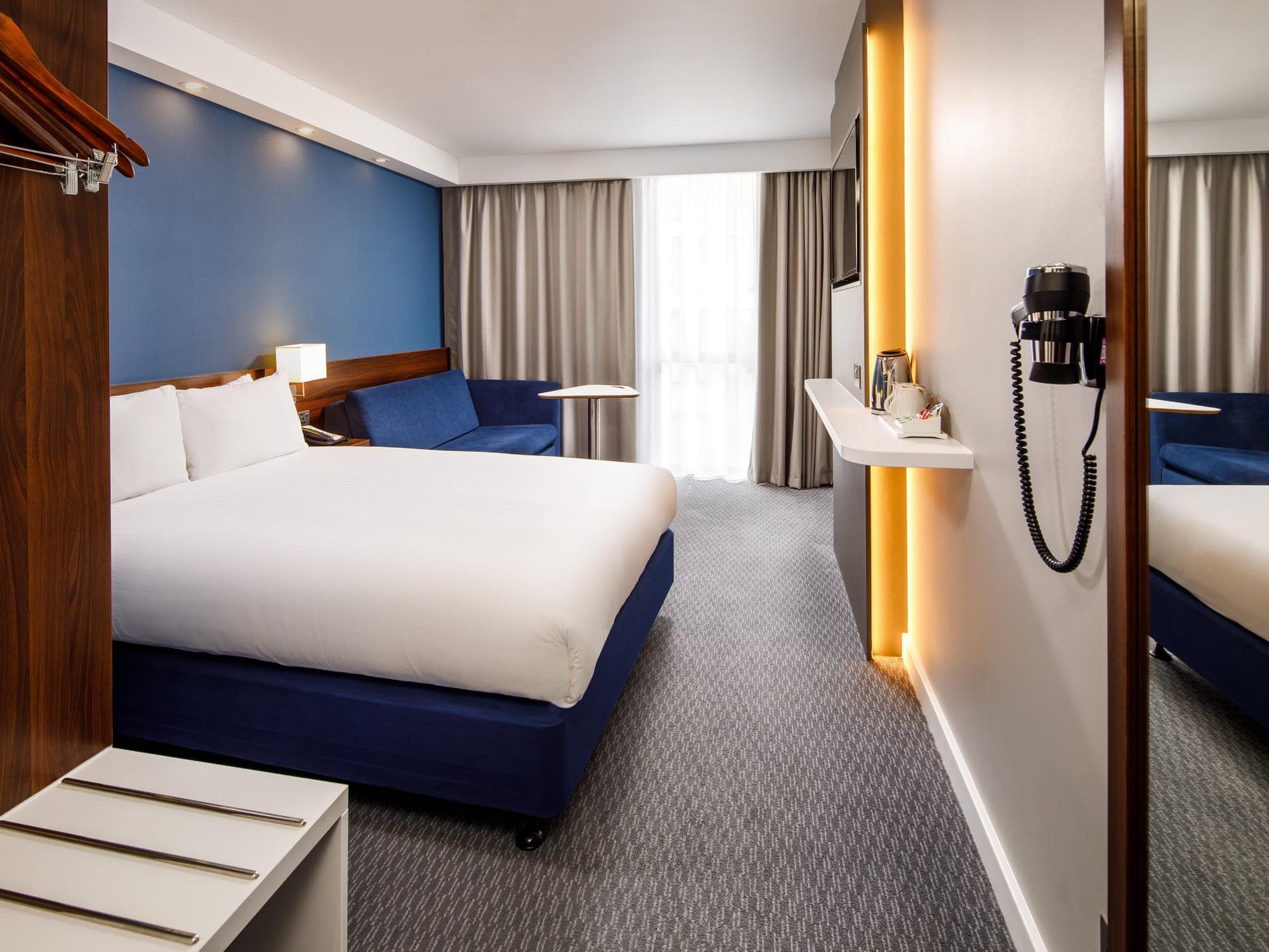 Hotel bedroom with full-height curtains and voiles