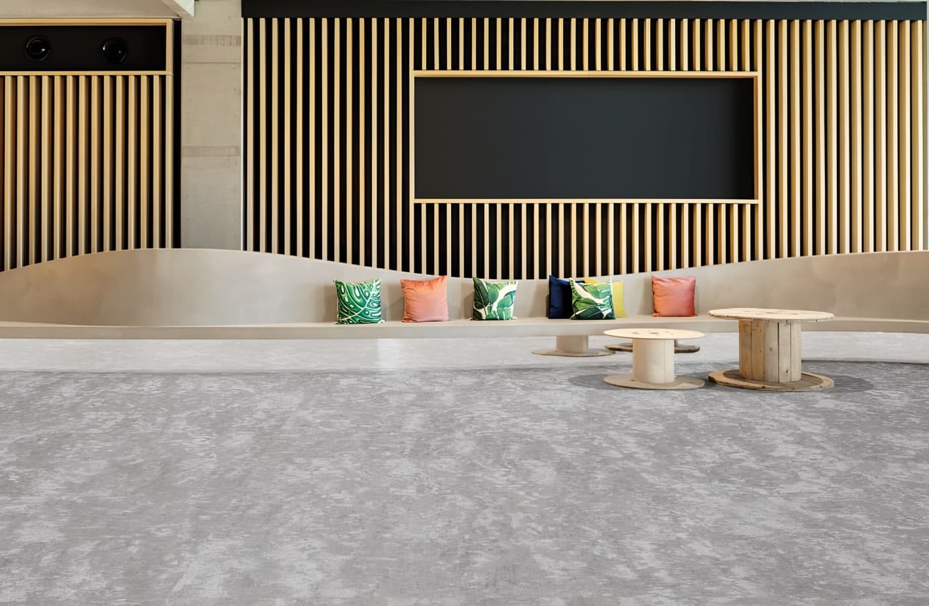 Lounge with a mottled grey woven floor and a slatted timber wall