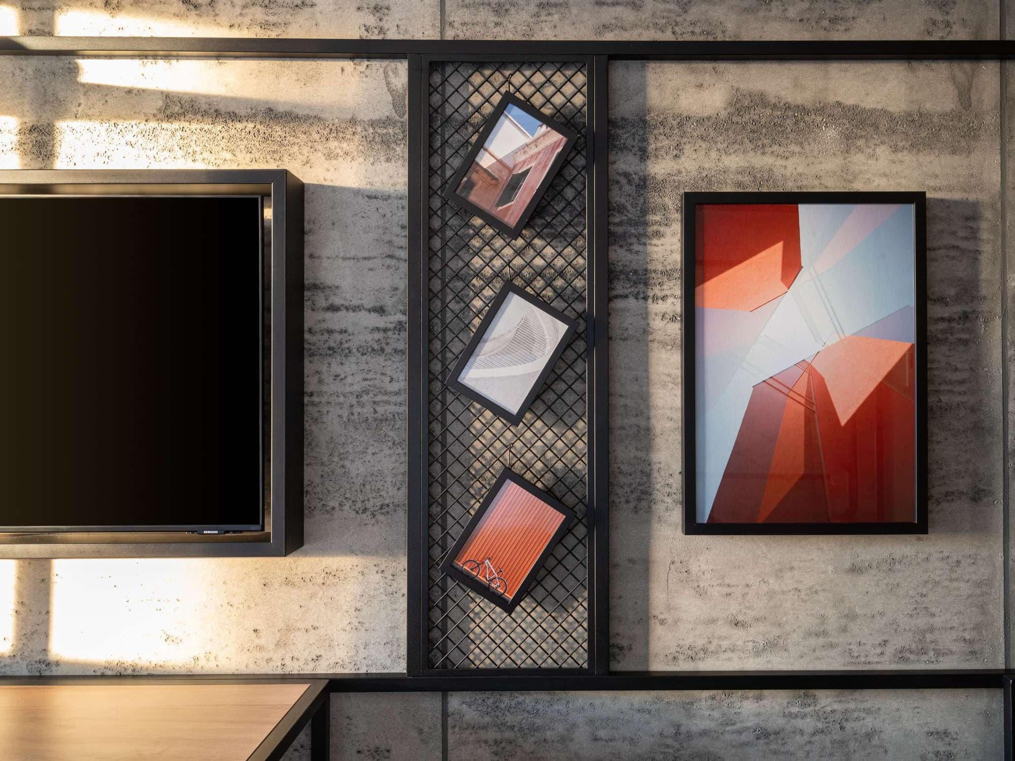 Stone-effect wall panels framing a television and a trellis of framed prints