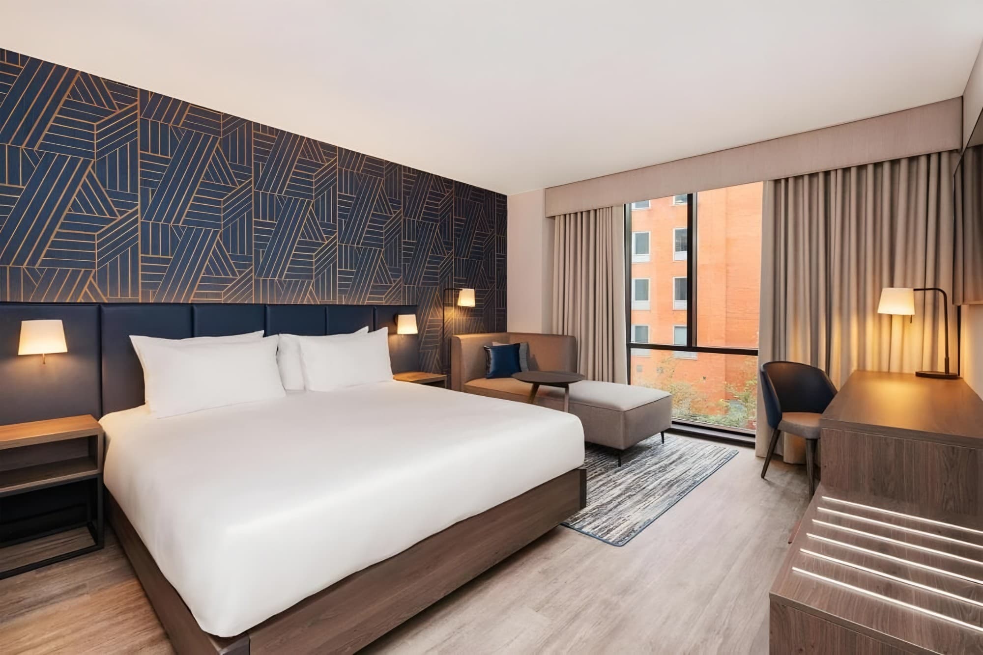 Hotel bedroom with curtains and a patterned feature wall