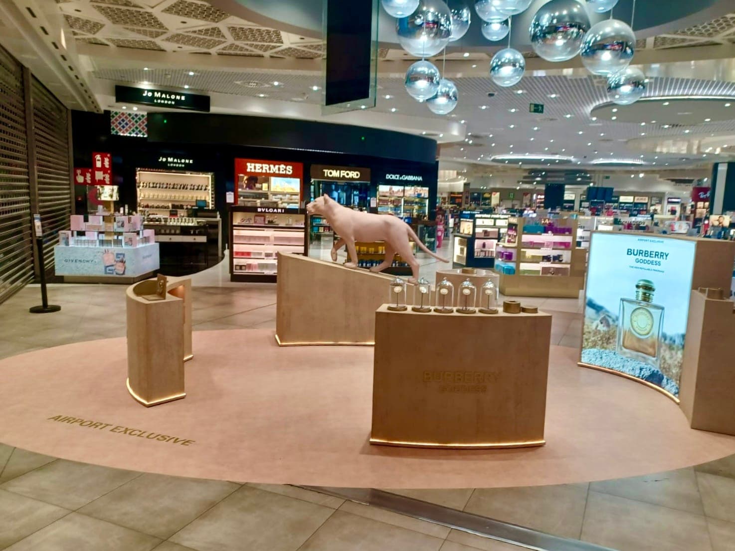 Burberry Goddess installation in a shopping centre, pink plinths beneath mirrored ceiling spheres