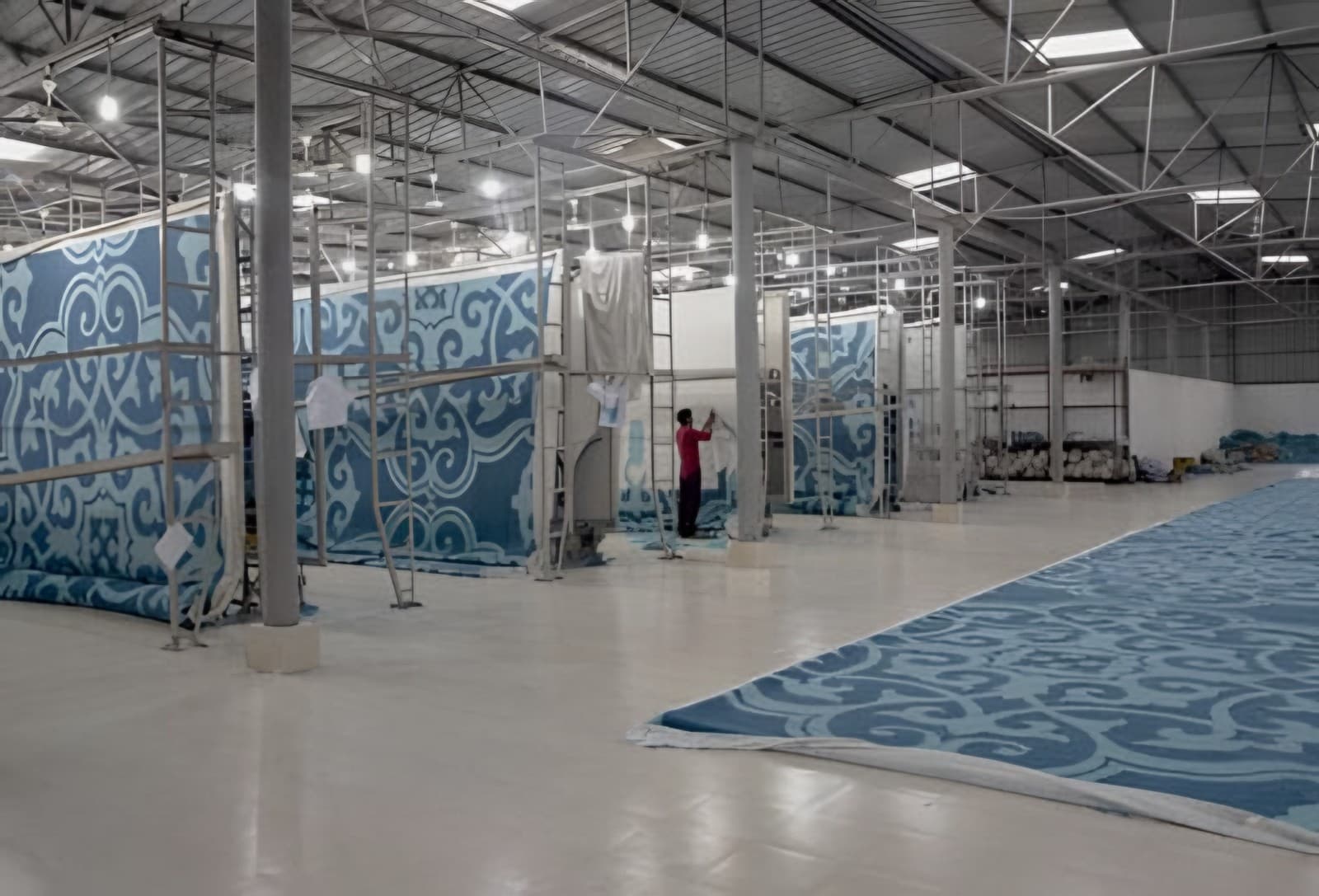 Large patterned rugs hung up in the workshop