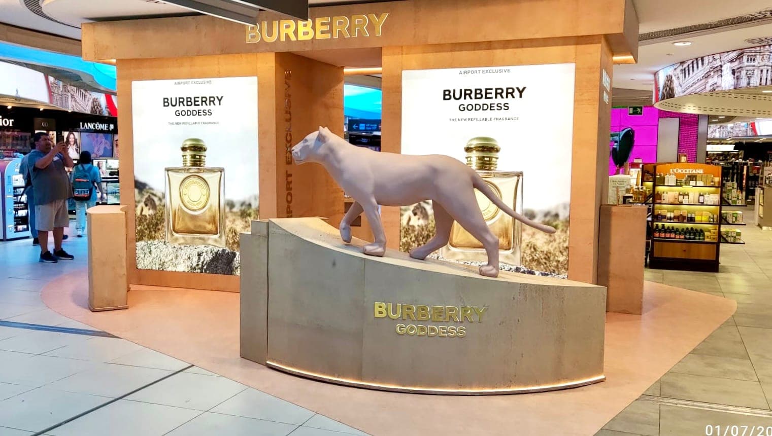 Pink stone-clad fragrance plinths and a lioness figure beside the Burberry light boxes