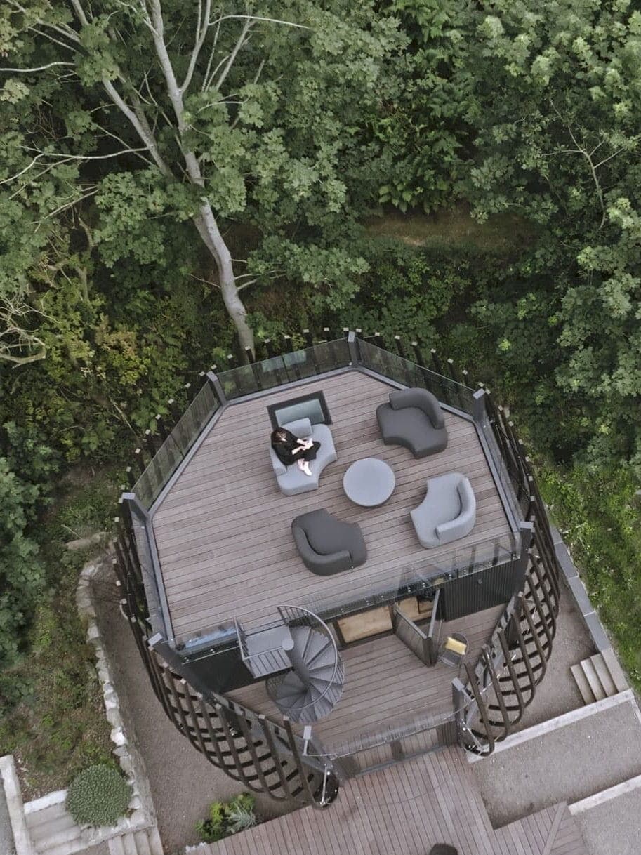 Aerial view of The Poppy's roof terrace, furnished with lounge chairs among the trees