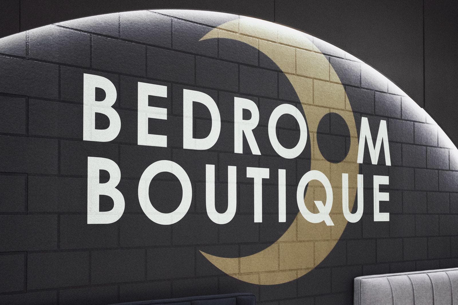 Bedroom Boutique sign with a gold crescent moon on a dark brick-pattern wall