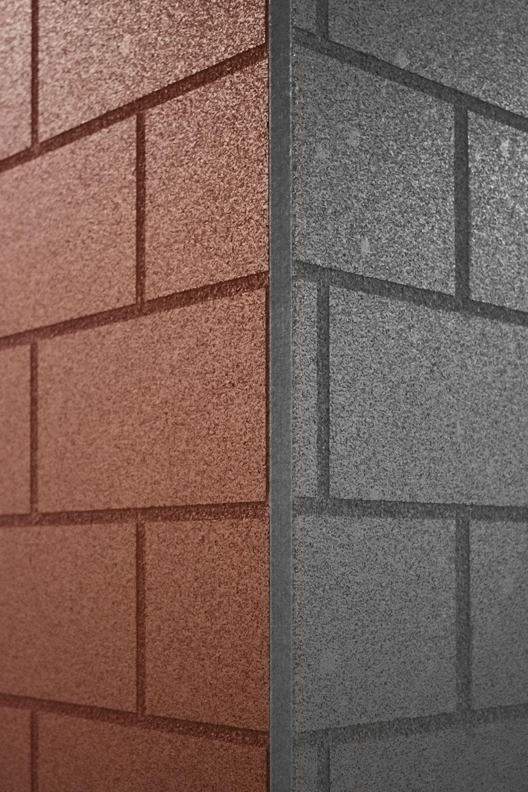Close-up of a corner where terracotta and charcoal brick-pattern textured wall finishes meet