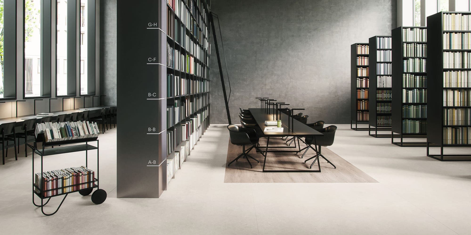 Library with tall black bookcases and a long reading table on a pale stone-effect floor