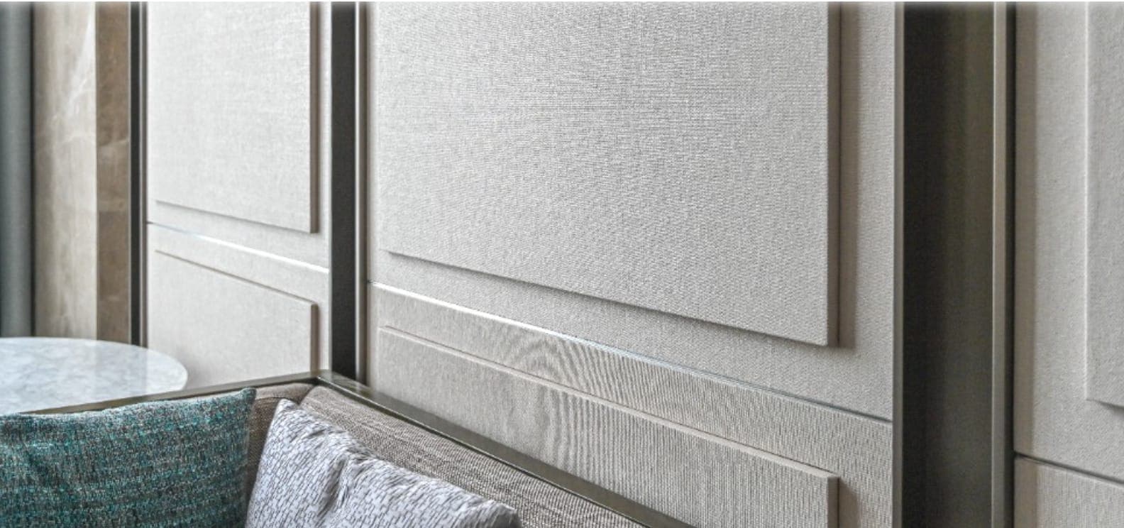 Panelled wall in a textured natural wallcovering beside a window seat